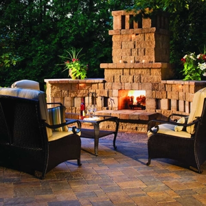 Stone outdoor fireplace with three chairs and center table